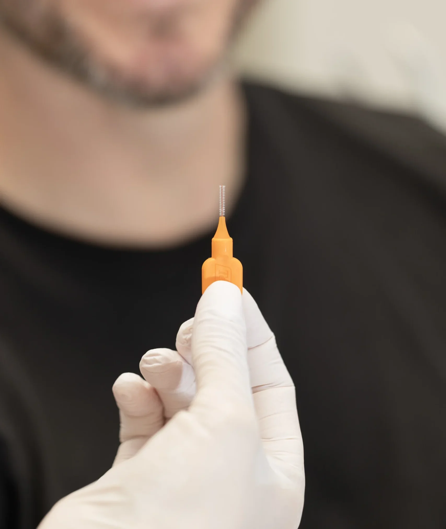 Patient mit Interdentalbürste, Prophylaxe beim Zahnarzt in Bad Oldesloe